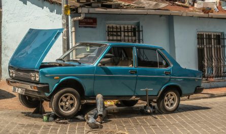 a blue car parked in front of a blue building